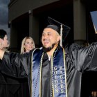 West Hills College Lemoore's Aaron Estrada gives high fives to faculty members following Thursday's graduation ceremony in the Golden Eagle Arena.
